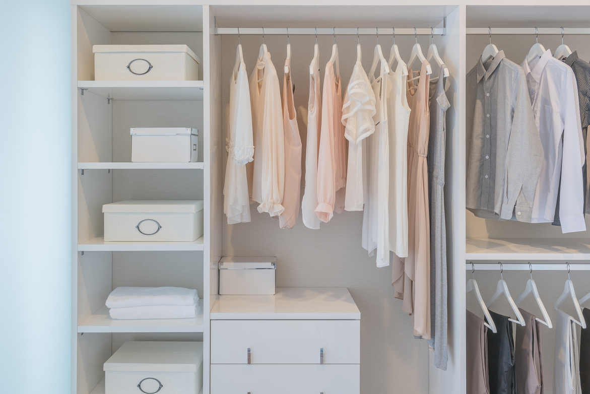 clothes hanging on rail in white wardrobe